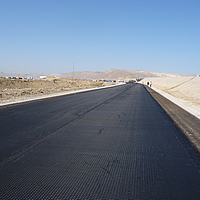 Une route inachevée montre une couche de HaTelit sans revêtement d'asphalte