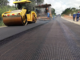 L'asphalte est appliqué à l'aide d'une goudronneuse, puis compacté sur HaTelit G à l'aide d'un rouleau.