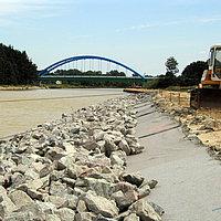 Géotextile non tissé et pierres en bordure de rivière pour la protection des berges