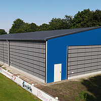 Façades pliantes grises sur la façade et le long côté d'un gymnase bleu