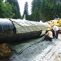 Les ouvriers placent l'Incomat® Pipeline Cover sur la section de tuyau