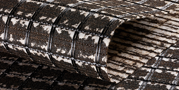Armature d'asphalte SamiGrid® - Gros plan sur le matériau Gros plan sur le composite SamiGrid® composé d'une grille PVA et d'un non-tissé saturé de bitume